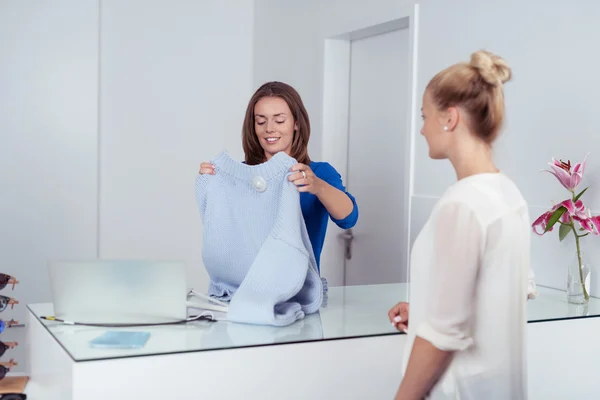 Shop assistant folding a garment — Stock Photo, Image