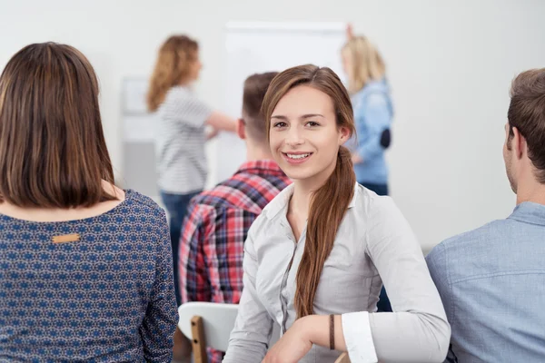 Aantrekkelijke dame in een vergadering glimlachend op de camera — Stockfoto