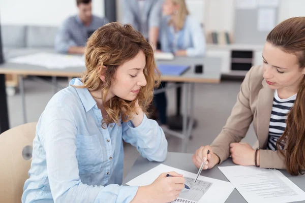 Två kontors kvinnor diskuterar dokumentet på bordet — Stockfoto