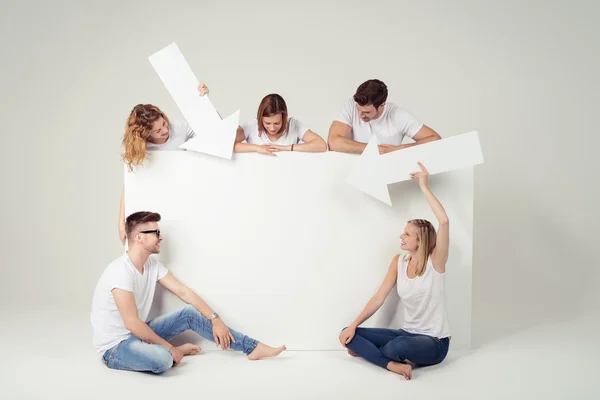 Young Friends with Arrows Looking at Empty Poster — Stockfoto