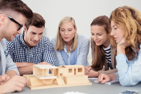 Jóvenes diseñadores mirando de cerca a la miniatura — Foto de Stock