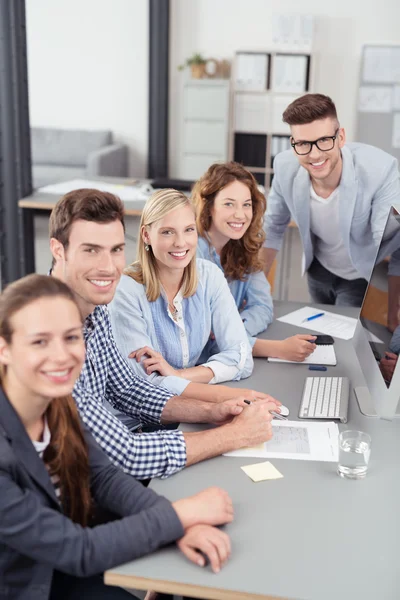 Lavoratori d'ufficio alla scrivania Sorridente alla macchina fotografica — Foto Stock