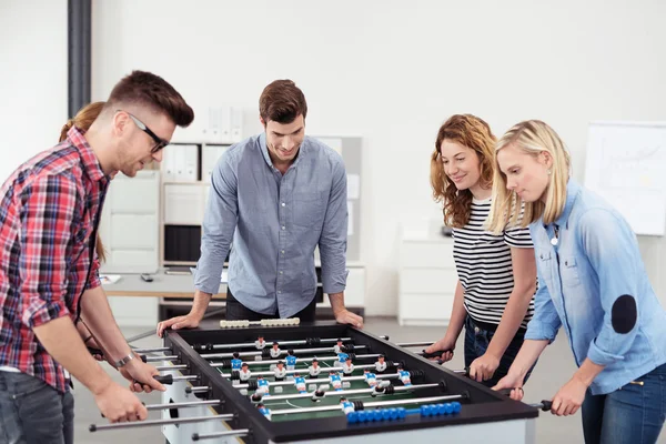 Jóvenes de oficina disfrutando del juego de fútbol de mesa — Foto de Stock