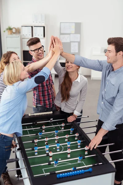 Workmates Putting Hands Together Over Soccer Table — Stock Fotó