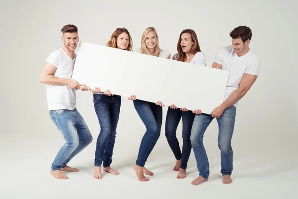 Cinco amigos segurando placa branca com espaço de cópia Fotografia De Stock