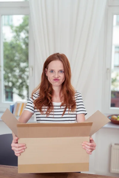 Jeune femme avec un visage drôle portant une boîte en carton — Photo