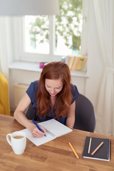 Menina atraente Escrevendo em suas notas na mesa — Fotografia de Stock