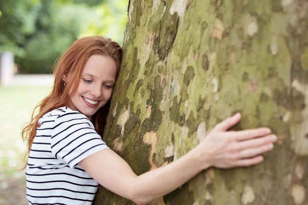 Mujer amante de la naturaleza abrazando un tronco de árbol grande —  Fotos de Stock