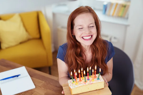 Glückliche Frau zeigt eine Geburtstagstorte — Stockfoto