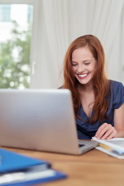 Женщина в своем домашнем офисе использует свой ноутбук — стоковое фото