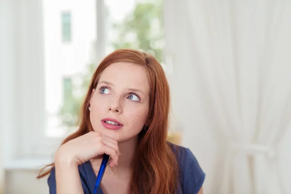 Thoughtful young woman looking up into the air — Stock Photo, Image