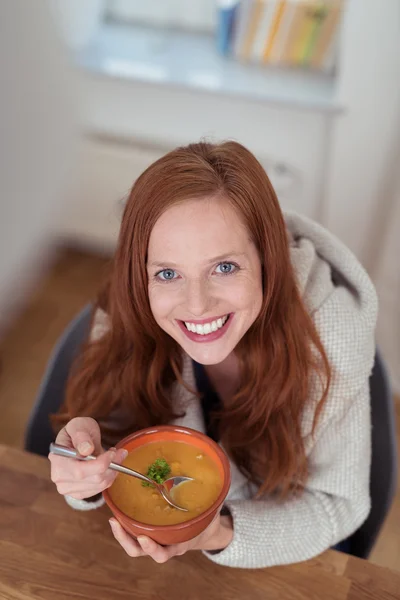 Donna che tiene una ciotola di zuppa a tavola — Foto Stock