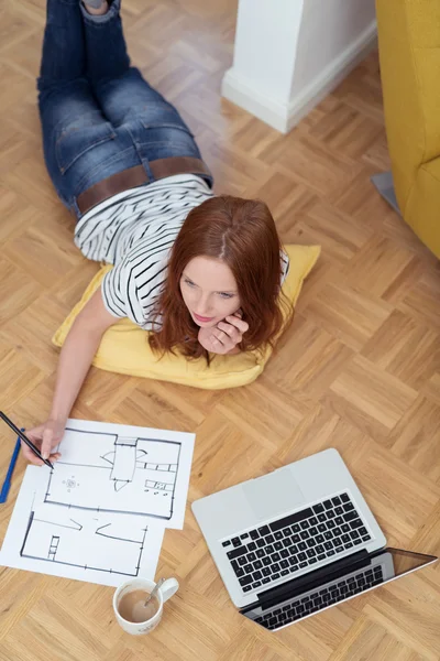 Thoughtful Woman Sketching on Paper on the Floor — ストック写真