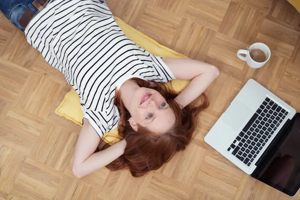 Mujer relajándose en el suelo con las manos detrás de la cabeza — Foto de Stock