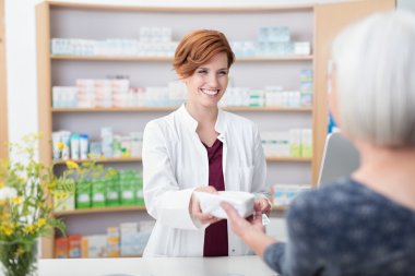 Pharmacist handing over prescribed medicines clipart