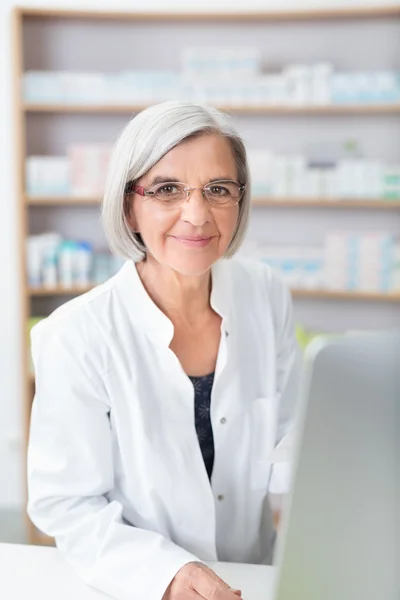 Senior lady pharmacist at work in the pharmacy — Stok fotoğraf