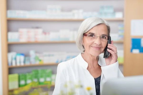 Lächelnder Seniorapotheker nimmt Anruf entgegen — Stockfoto