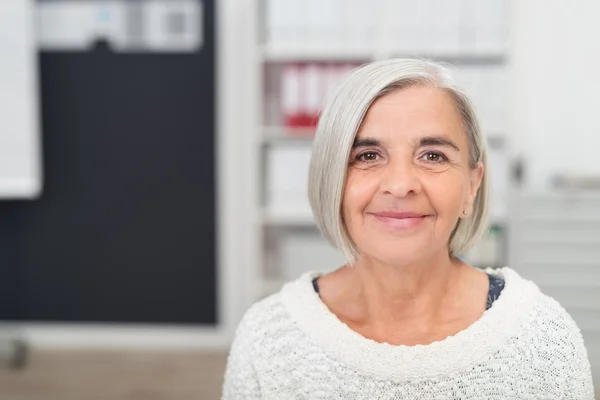 Grigio dai capelli ufficio donna sorridente a il fotocamera — Foto Stock