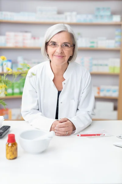 Friendly senior female pharmacist — ストック写真