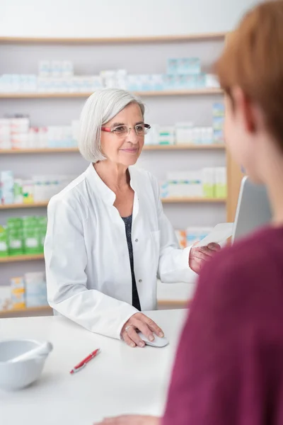 Farmacista donna anziana che elabora una prescrizione — Foto Stock