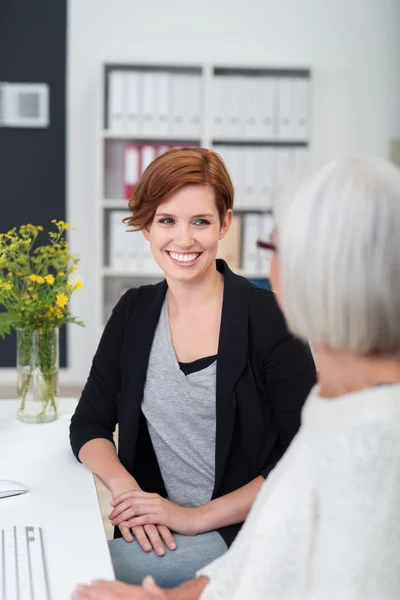 Giovane ufficio donna ascolta senior collega — Foto Stock