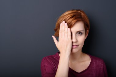 young redhead woman covering one eye clipart