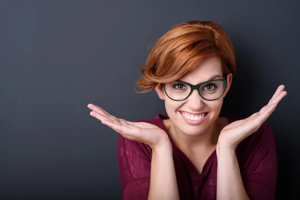 Joyeux jeune femme avec les mains ouvertes contre gris — Photo