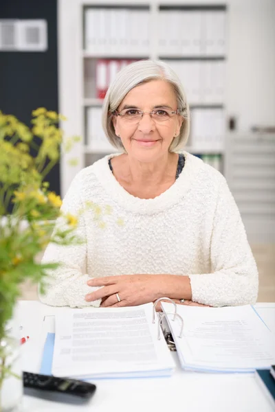 Senior Businesswoman al suo tavolo con documenti — Foto Stock