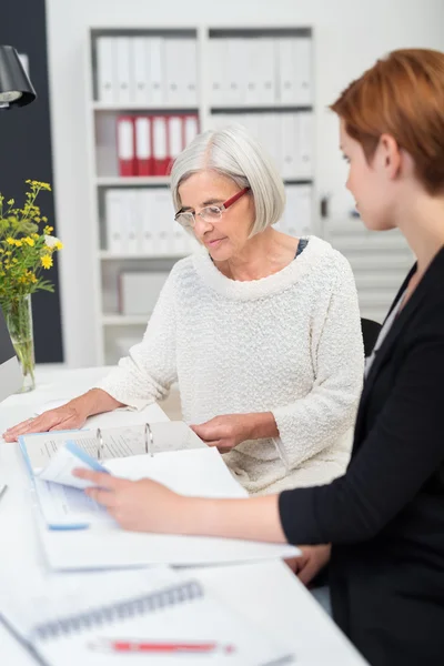 Dos empresarias leyendo documentos sobre la mesa — Foto de Stock