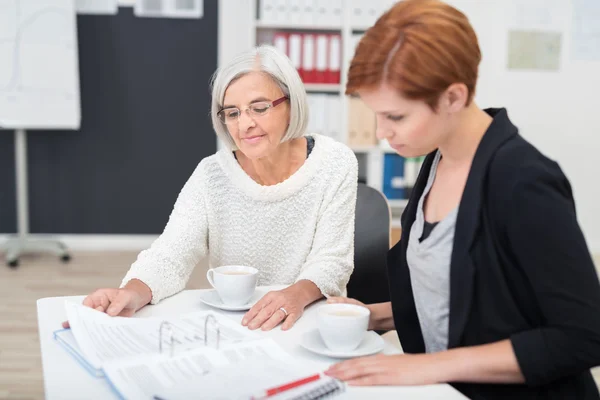 Mujeres de negocios con documentos de lectura de café — Foto de Stock