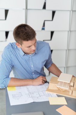 Architect Assembling House Miniature on the Table clipart