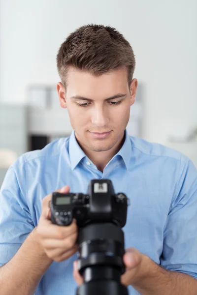 Guapo fotógrafo mirando fotos en la cámara — Foto de Stock