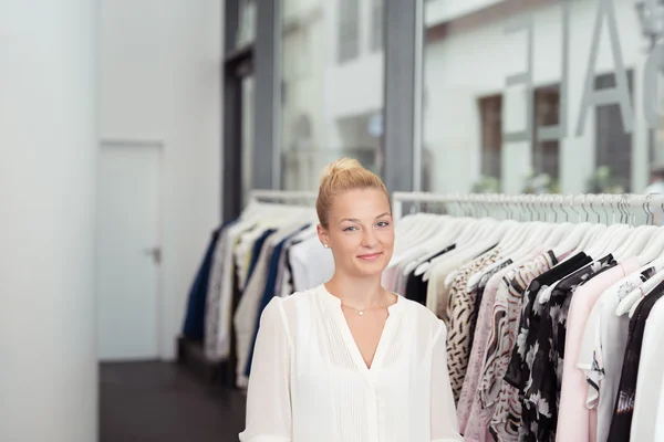 Atractiva chica en la tienda de ropa sonriendo a la cámara —  Fotos de Stock