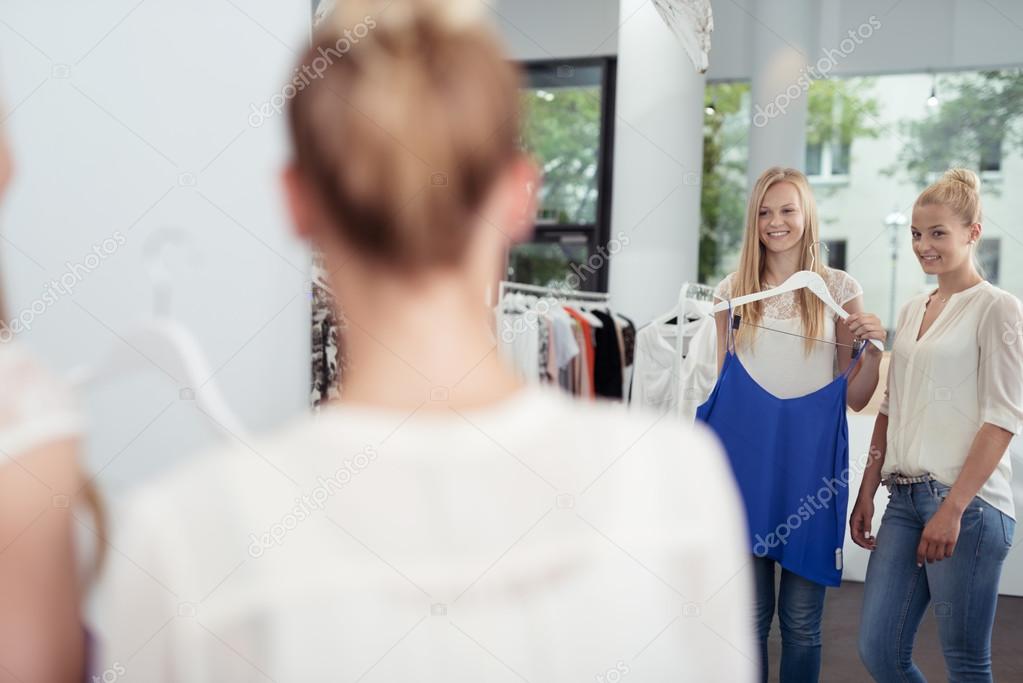 friends checking out clothes in front of a mirror stockfoto checking out