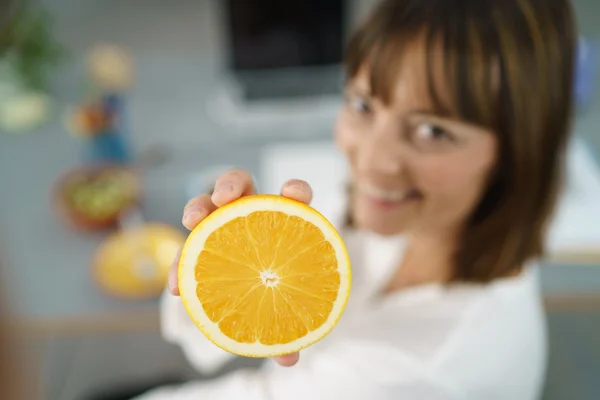 Happy Office kvinna med en skivad apelsin — Stockfoto