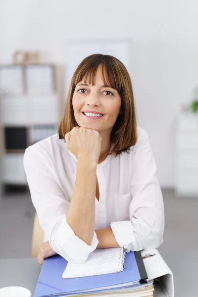 Vrolijke Office vrouw leunend op haar tafel — Stockfoto