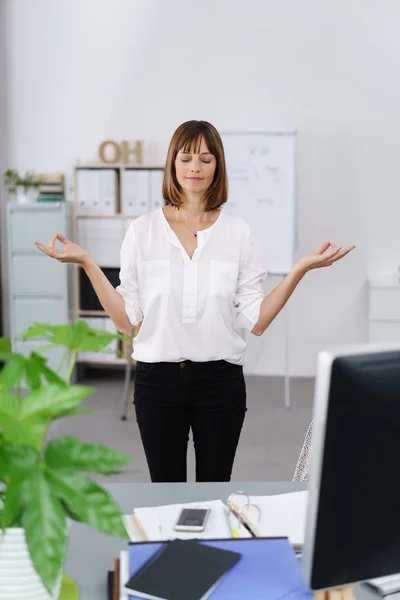 Businesswoman standing meditating — Stockfoto