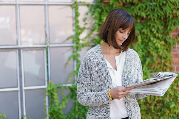 Businesswoman standing reading documents — Φωτογραφία Αρχείου