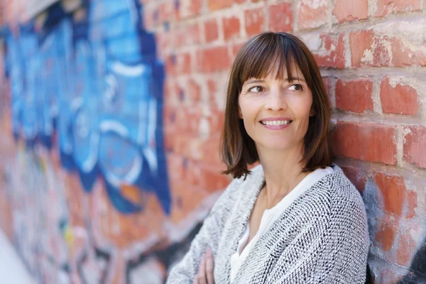 Frau lehnt an Wand — Stockfoto