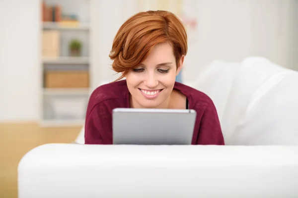 Attractive young redhead woman using a tablet — 스톡 사진