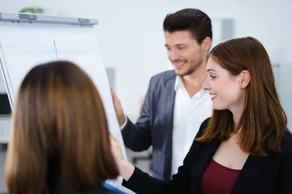 Drie zakenmensen permanent samen werken bij whiteboard — Stockfoto