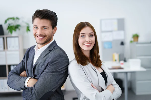 Twee collega's staan samen met de armen gevouwen — Stockfoto