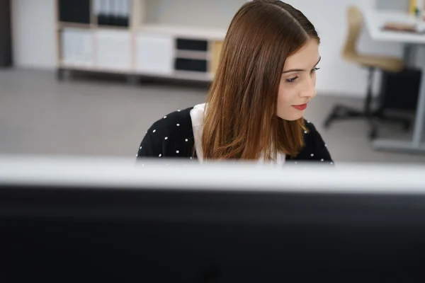 Attraktive junge Büroangestellte, die an ihrem Tisch arbeitet — Stockfoto