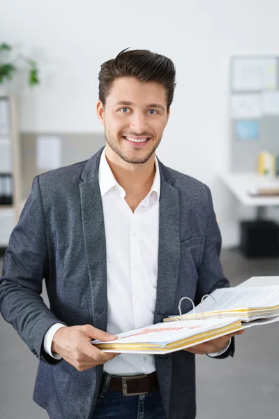 Junger Geschäftsmann hält einen Ordner in der Hand — Stockfoto