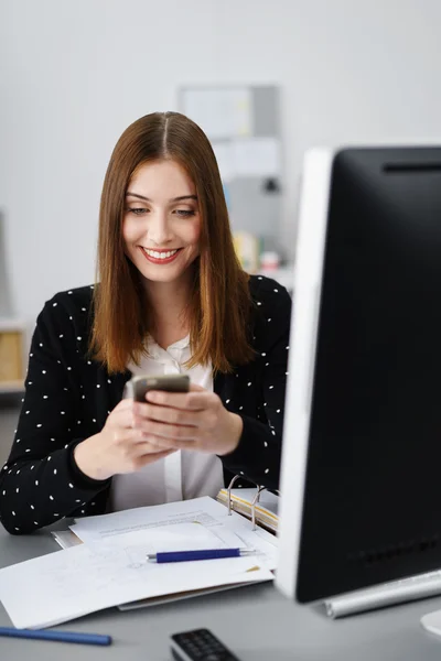 Glückliche Frau schaut auf ihr Handy — Stockfoto