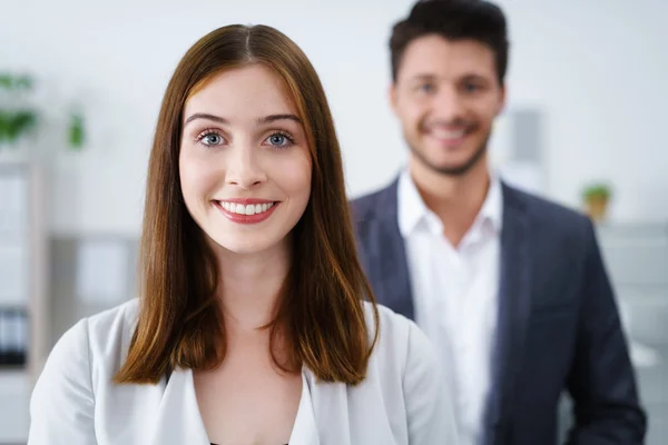 Atractiva mujer de negocios sonriente de pie dentro del lugar de trabajo —  Fotos de Stock