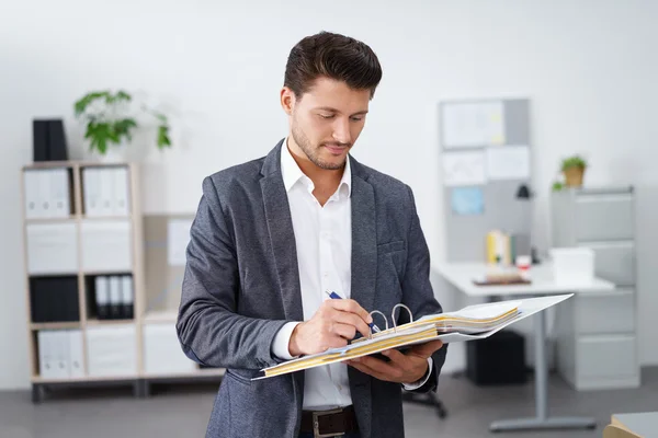 Hombre de negocios tomando notas en una carpeta — Foto de Stock