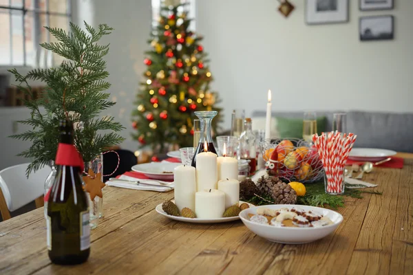 Mesa festiva con árbol de Navidad en el fondo — Foto de Stock