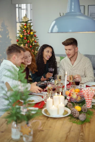 Quatro adultos comemorando o Natal em casa — Fotografia de Stock