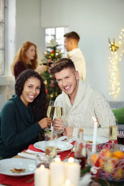 Sorrindo casal brindar com champanhe enquanto tendo jantar de Natal — Fotografia de Stock